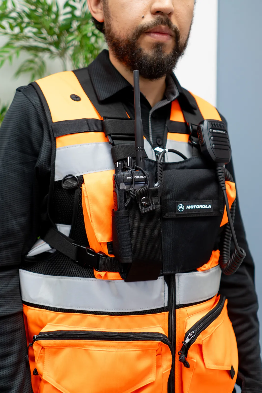 Trabajador con radio Motorola equipada en chaleco de seguridad en faena